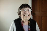 An older woman wearing glasses and a necklace