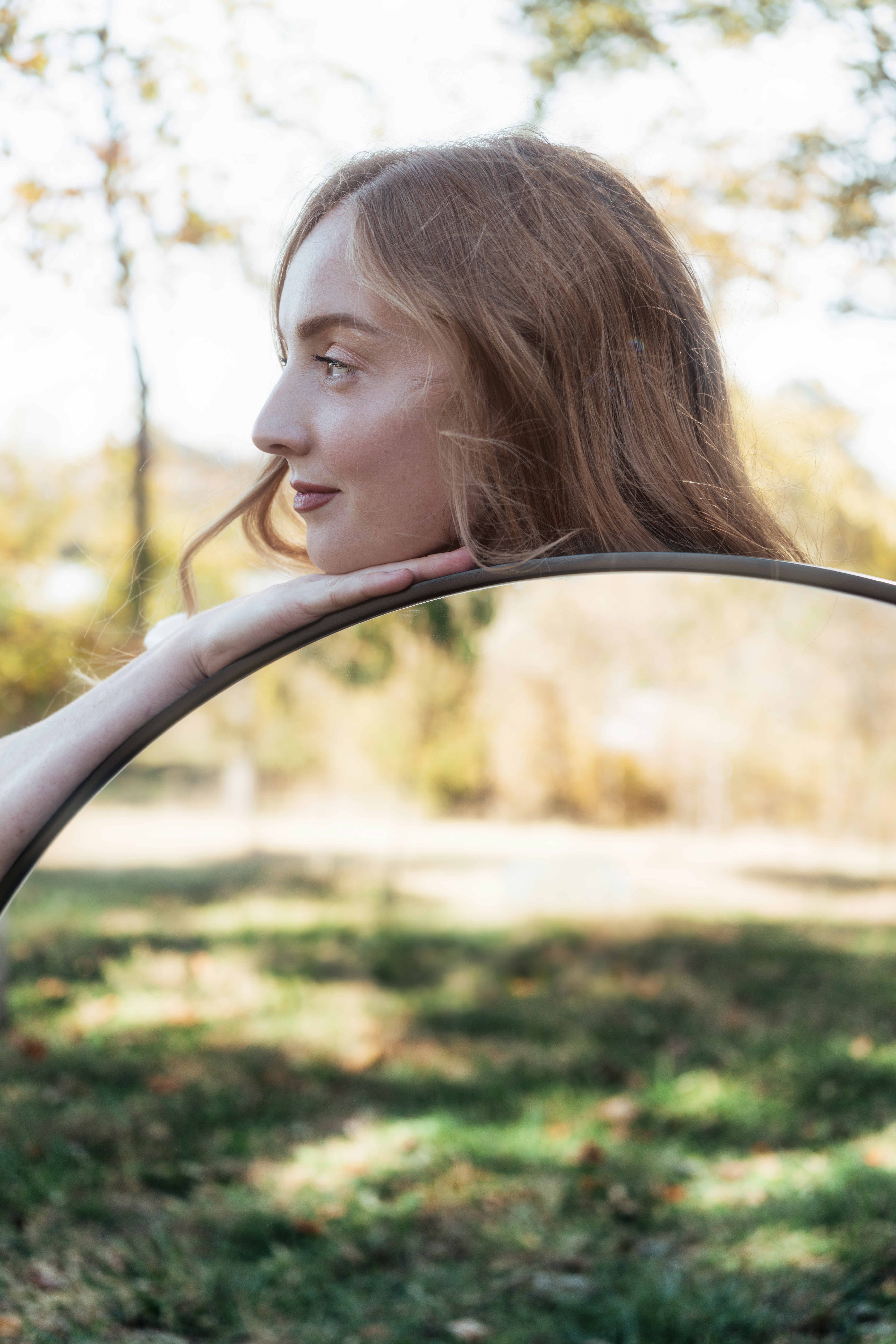 A woman with long hair is holding a circular object photo Free Mirror