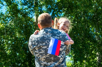 A soldier holding a little girl in his arms