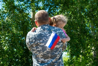 A soldier holding a little girl in his arms