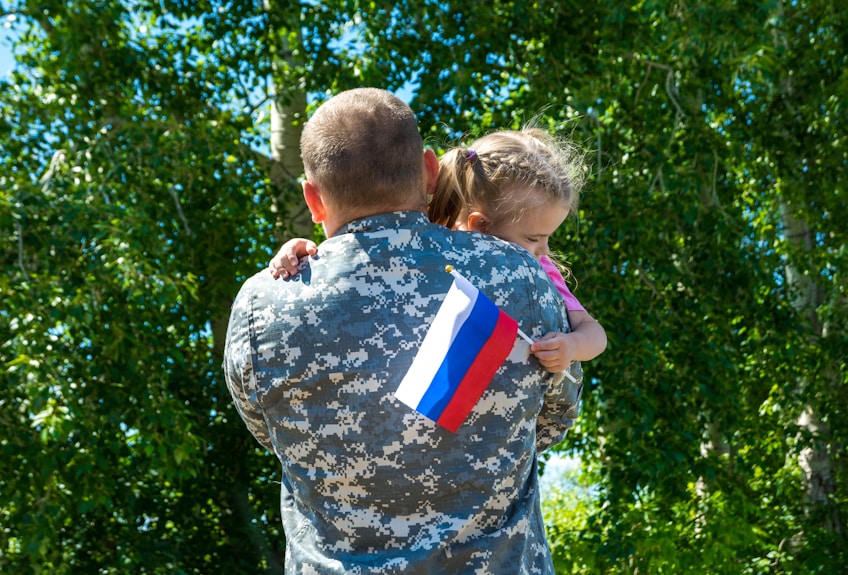 A soldier holding a little girl in his arms