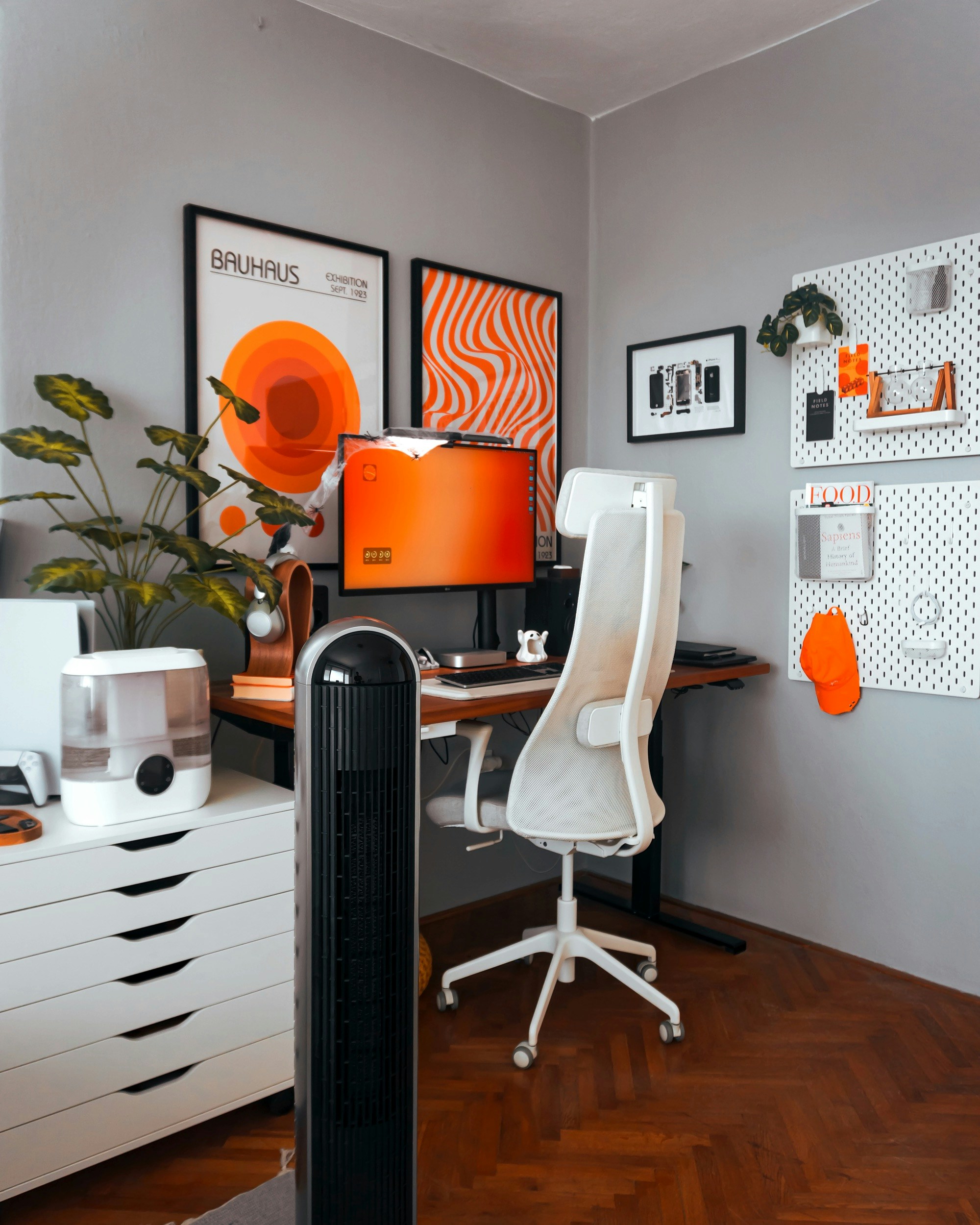 Uma sala com uma mesa, cadeira e quadros na parede