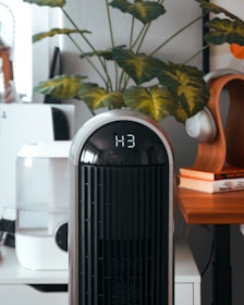 A black and white air purifier sitting on top of a wooden table