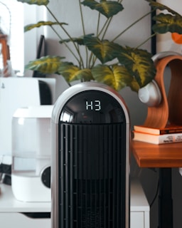 A black and white air purifier sitting on top of a wooden table