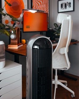 A room with a desk, chair, and air conditioner