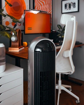 A room with a desk, chair, and air conditioner