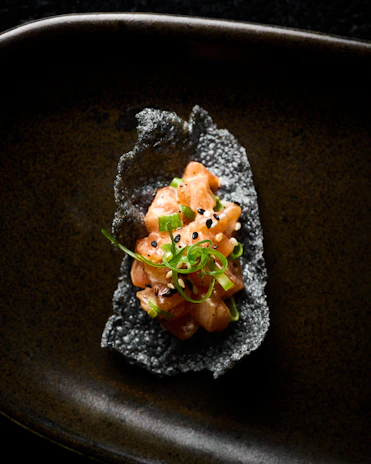 A black plate with some food on top of it