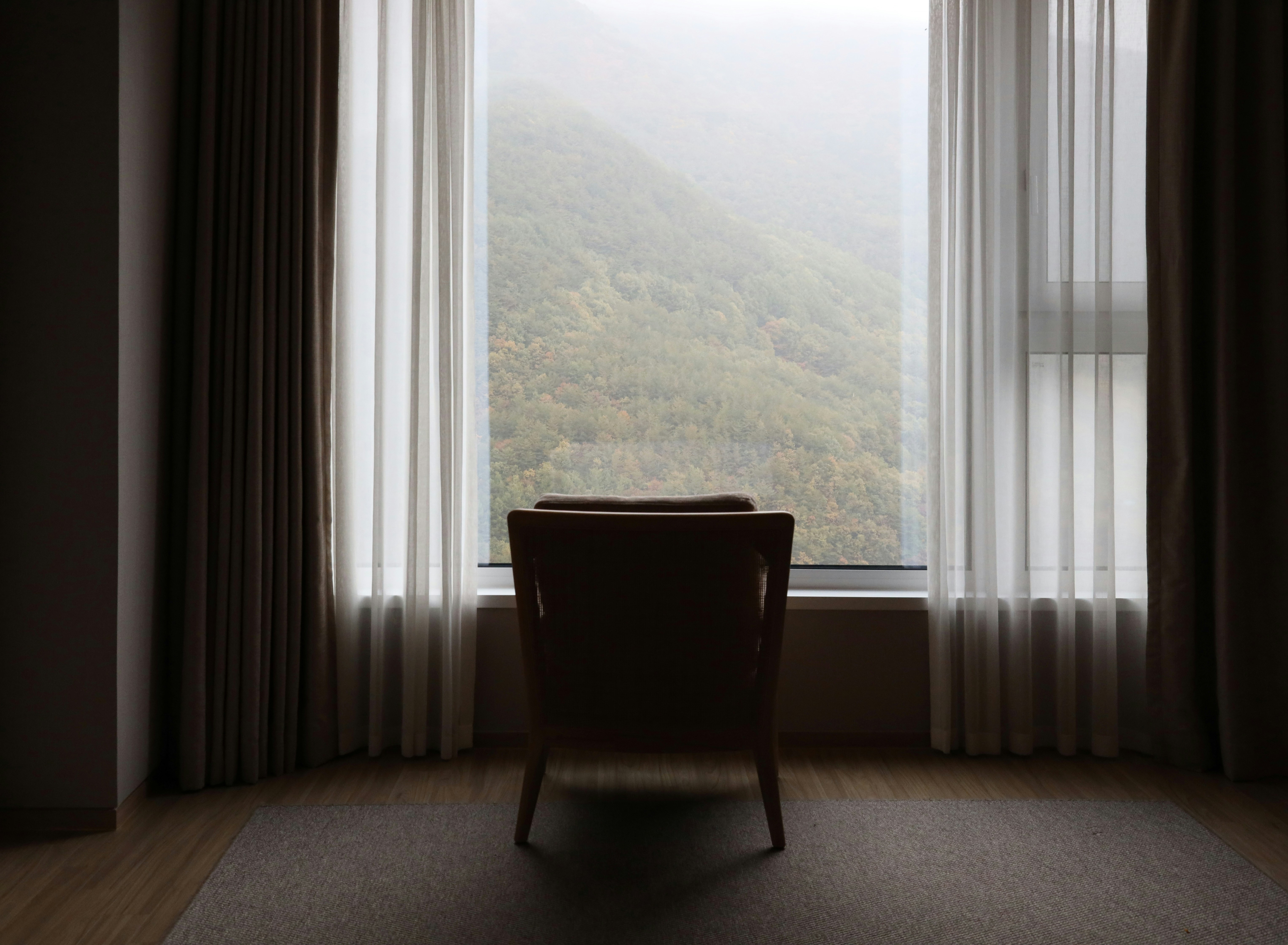 Una sedia seduta davanti a una finestra in una stanza