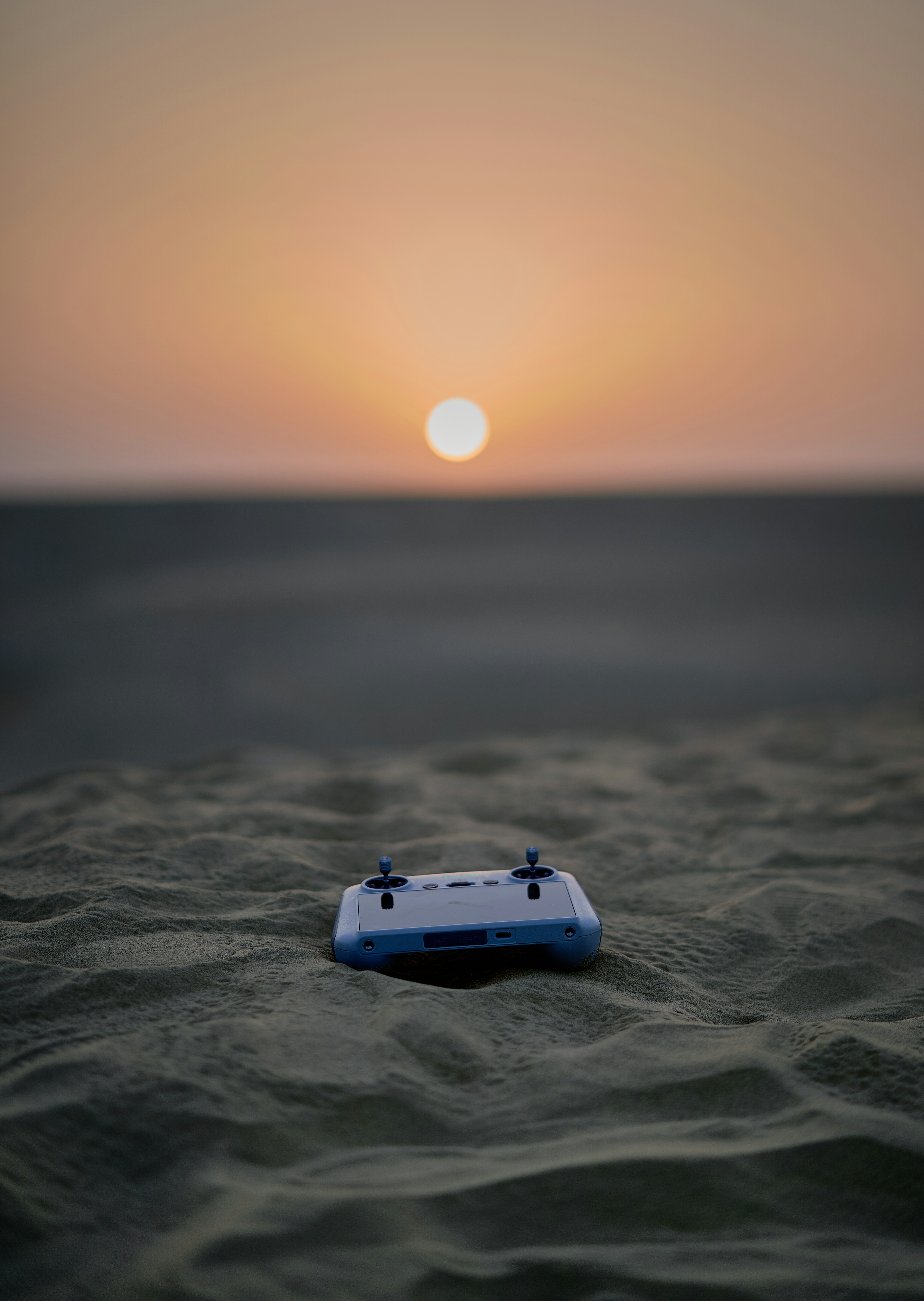 A toy boat floating on top of a sandy beach