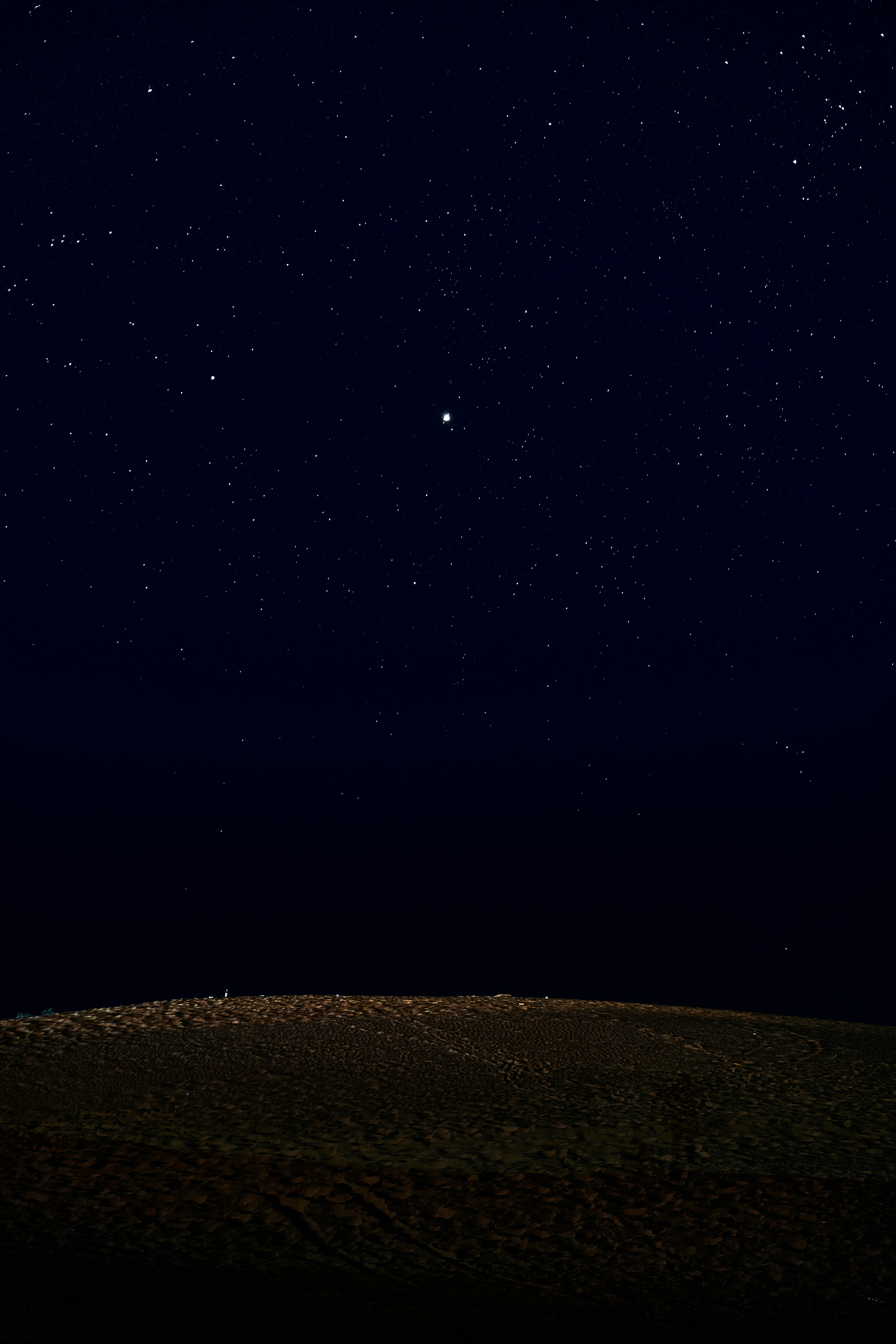 The night sky is full of stars above a hill