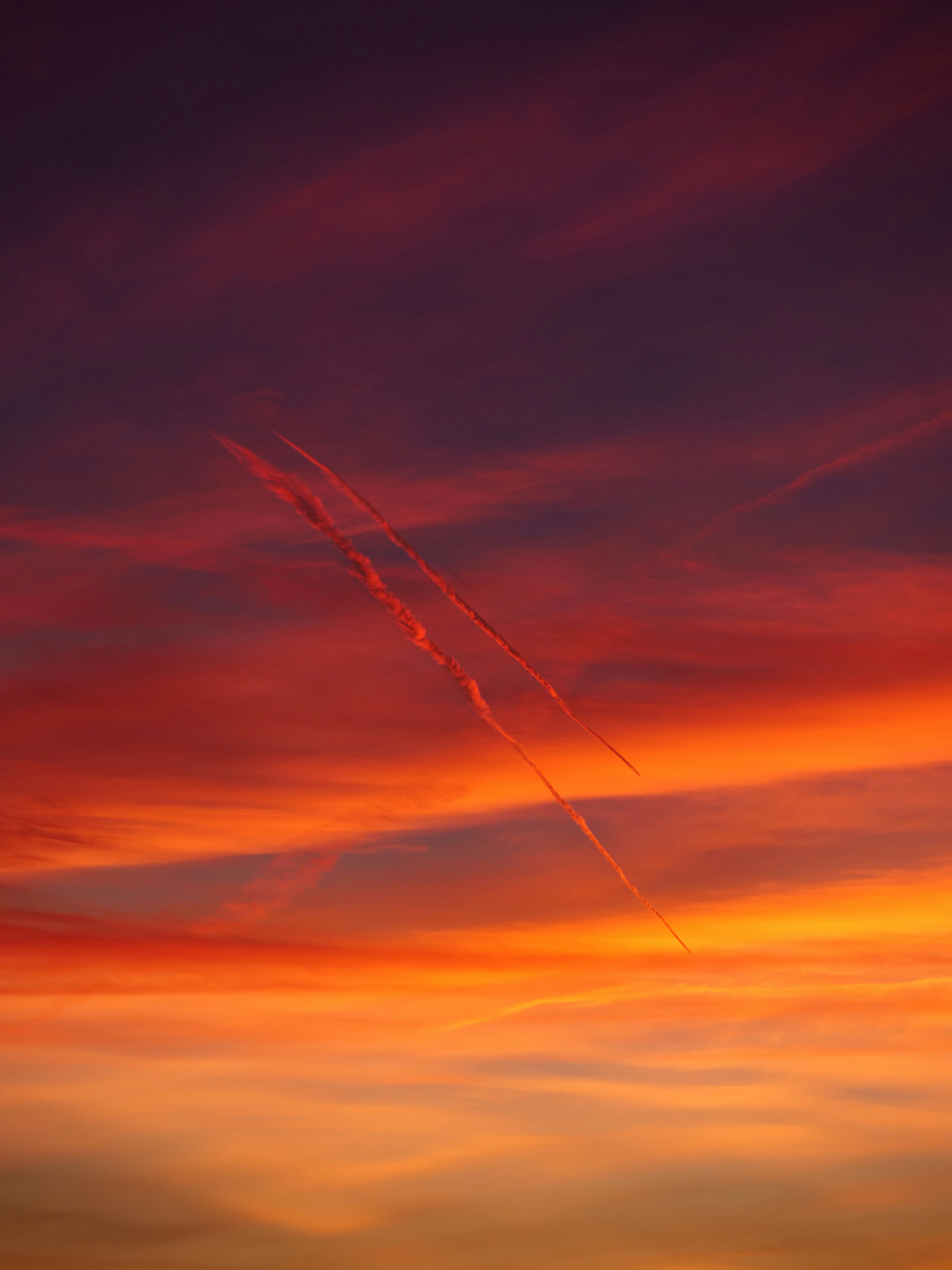 A plane is flying in the sky at sunset