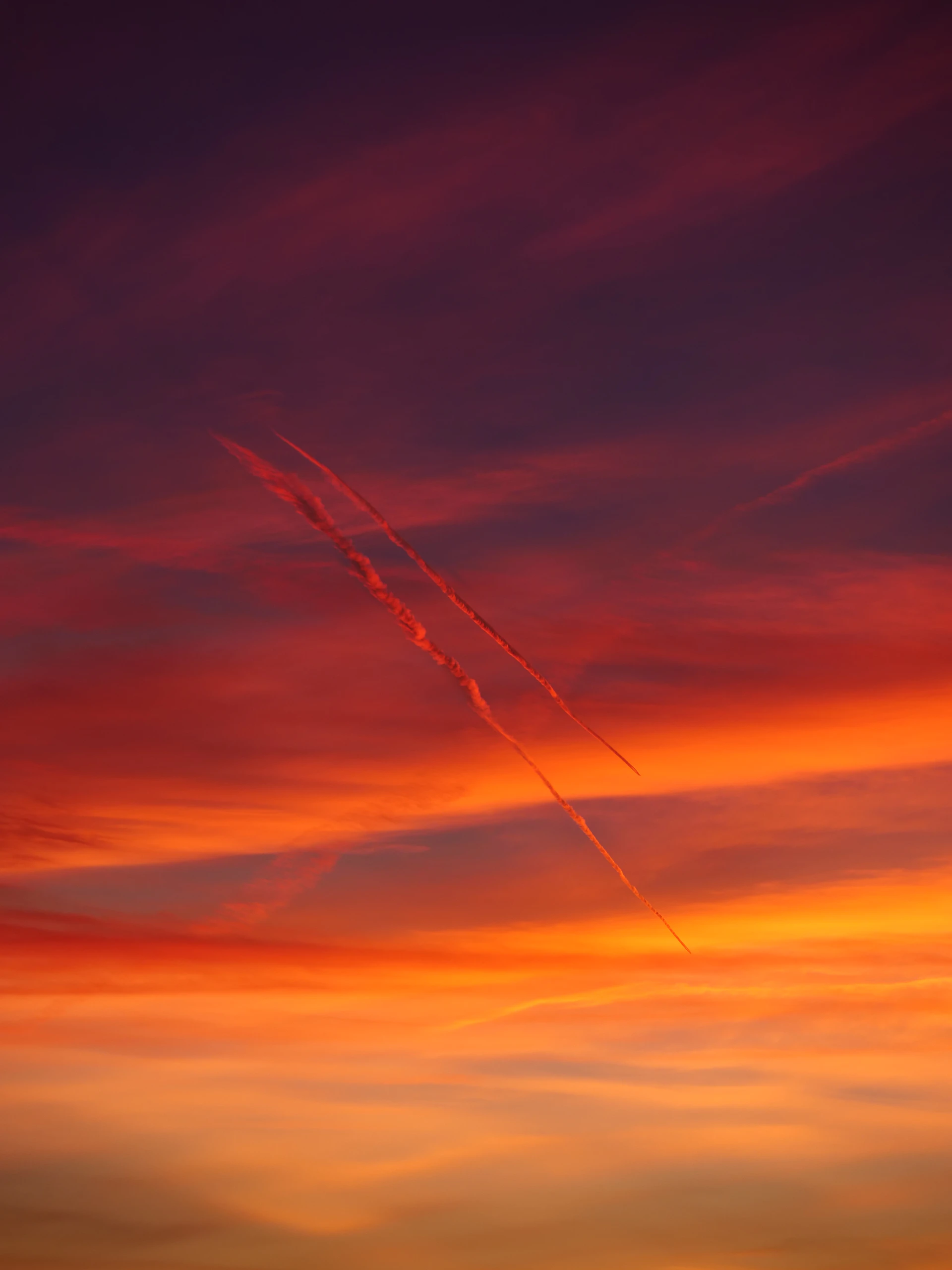 A plane is flying in the sky at sunset