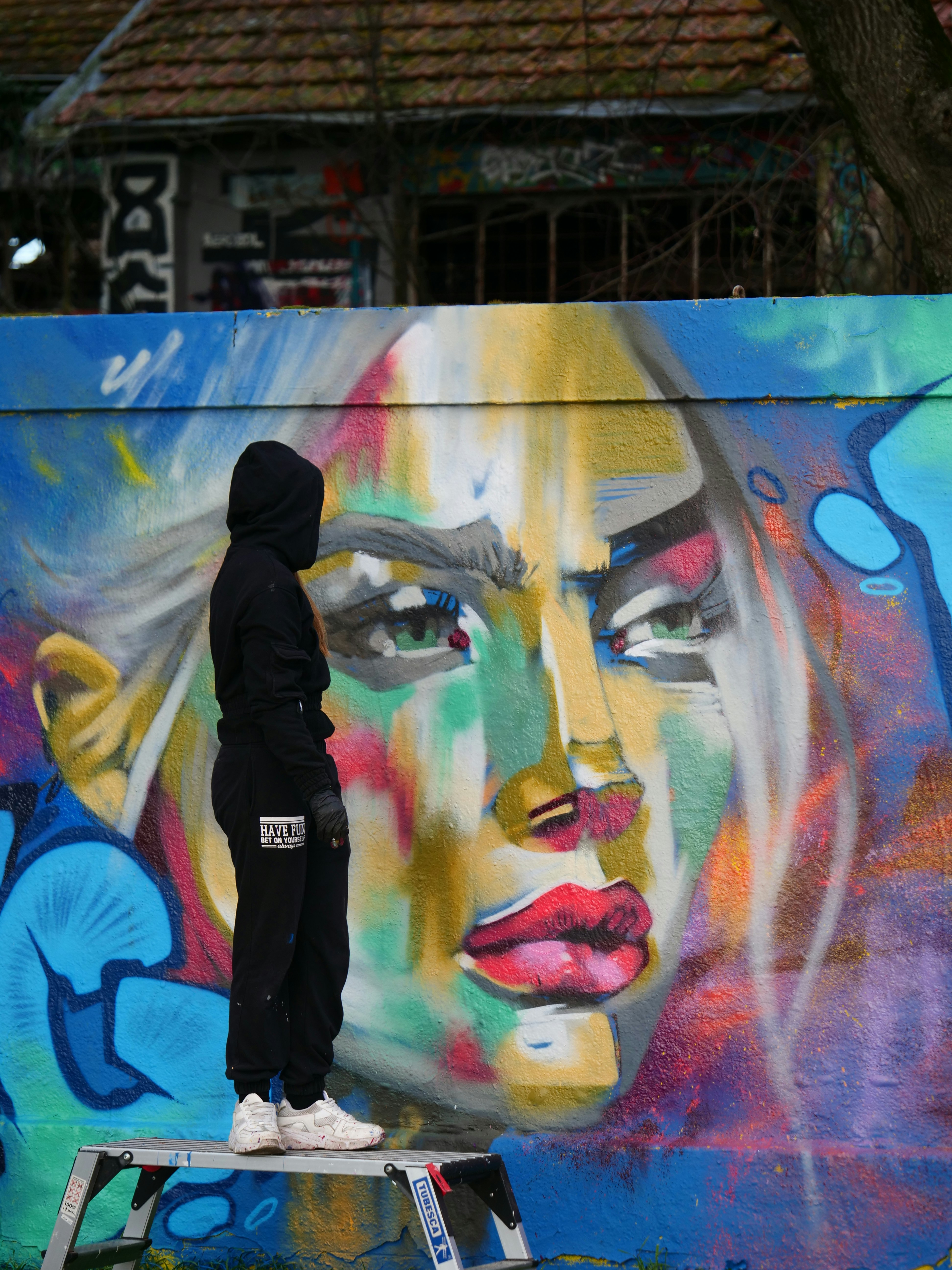 Artiste de street art travaillant sur une toile