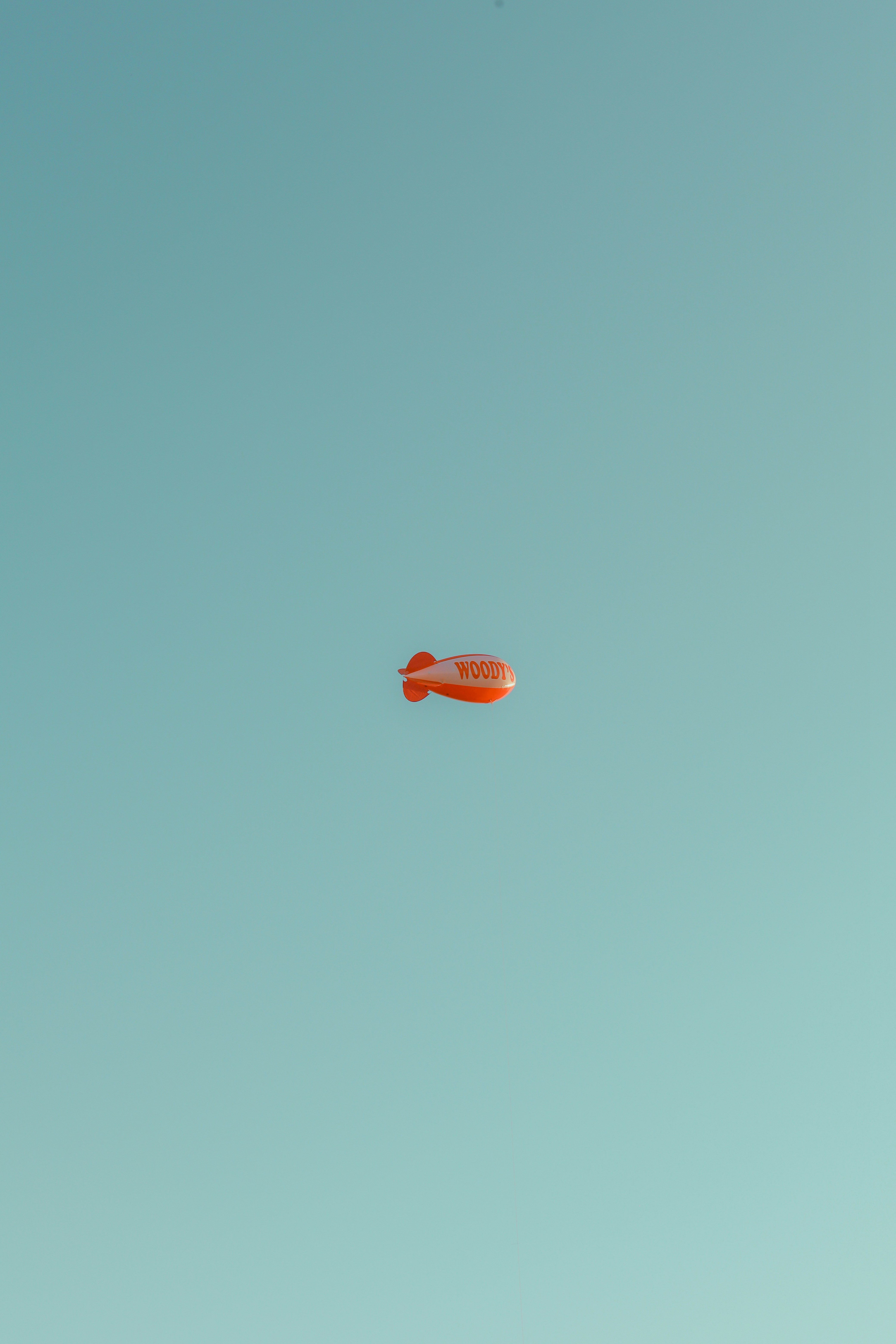 A red frisbee flying through a blue sky
