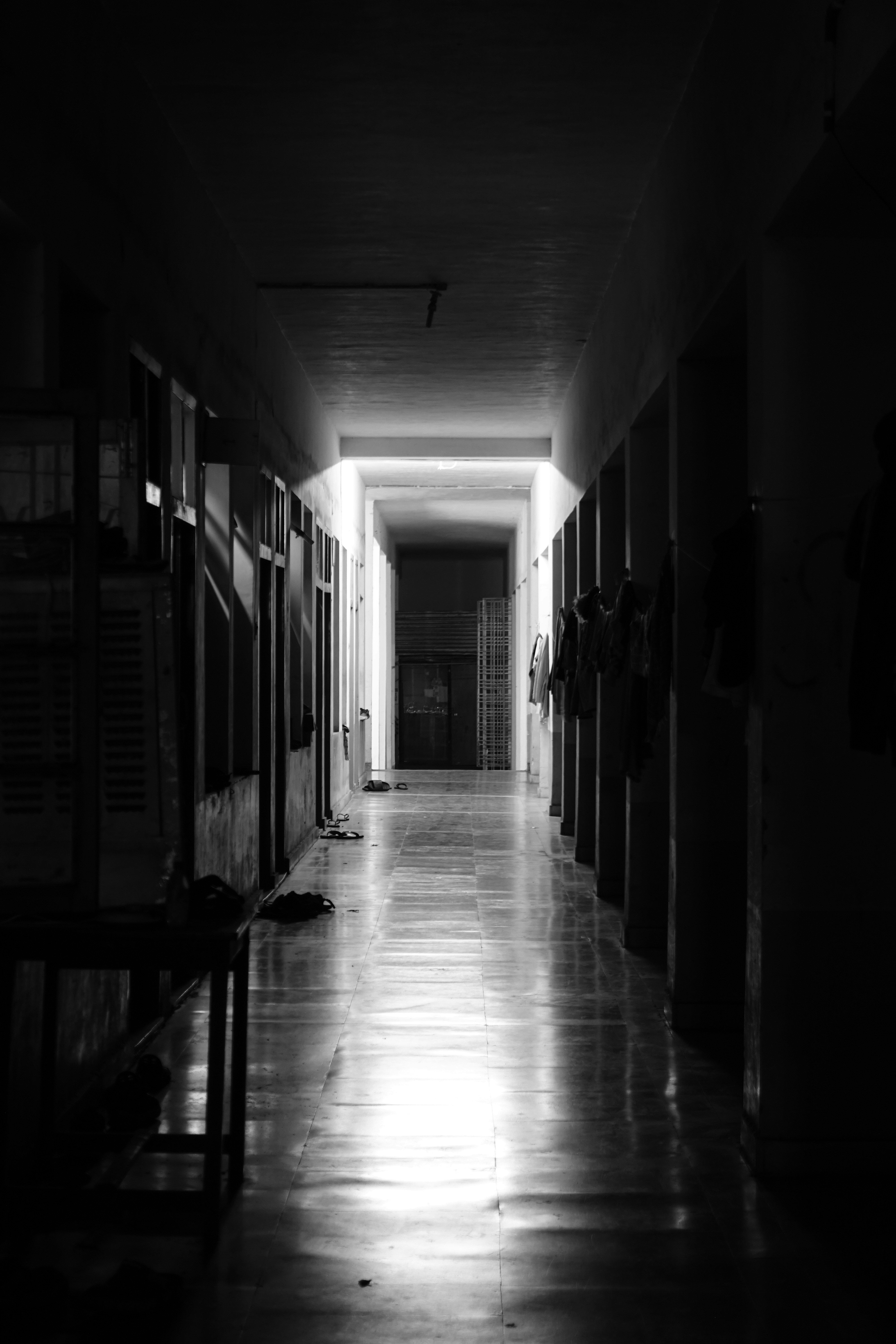 A long dark hallway with a bench in the middle