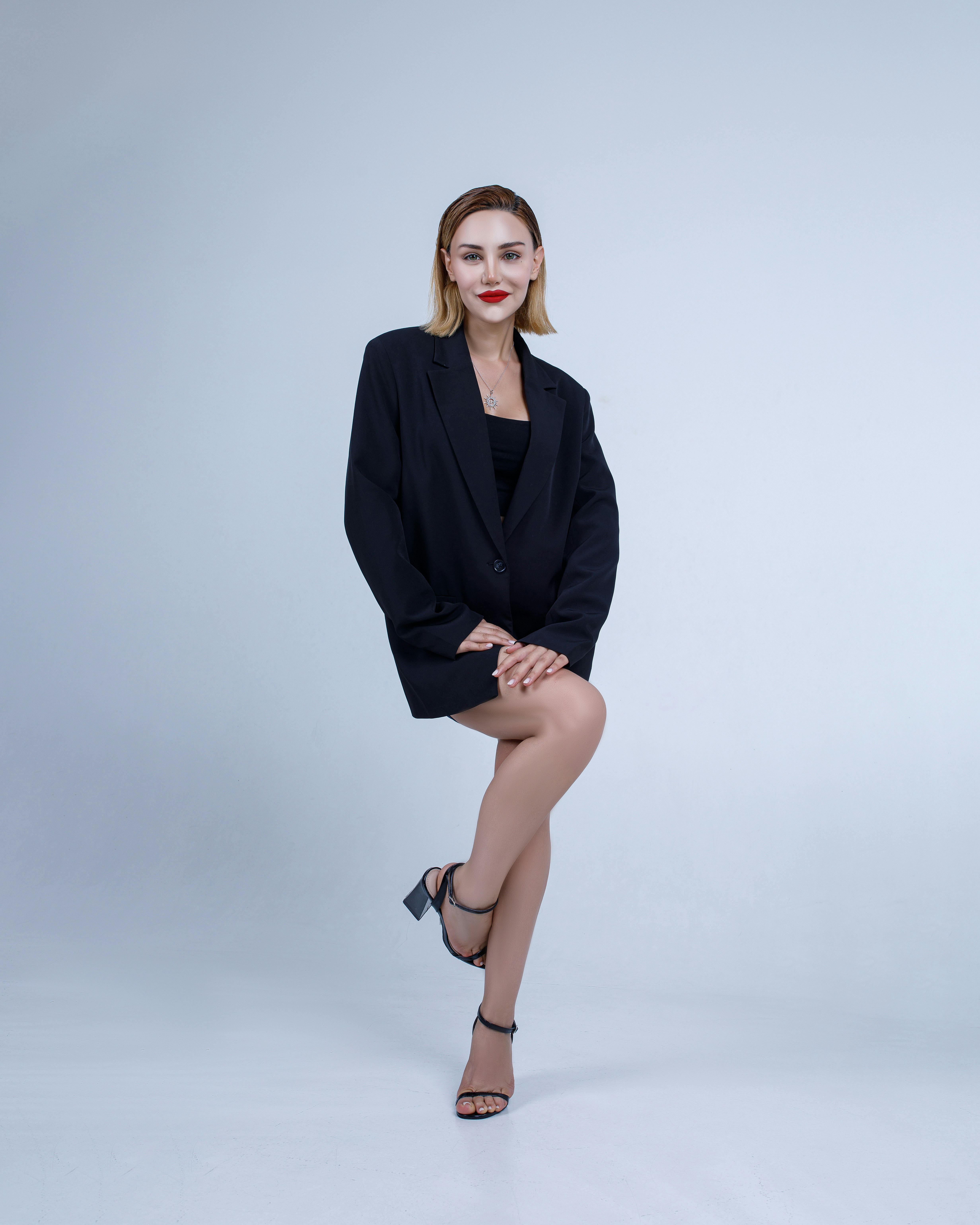 A woman posing for a picture with her legs crossed