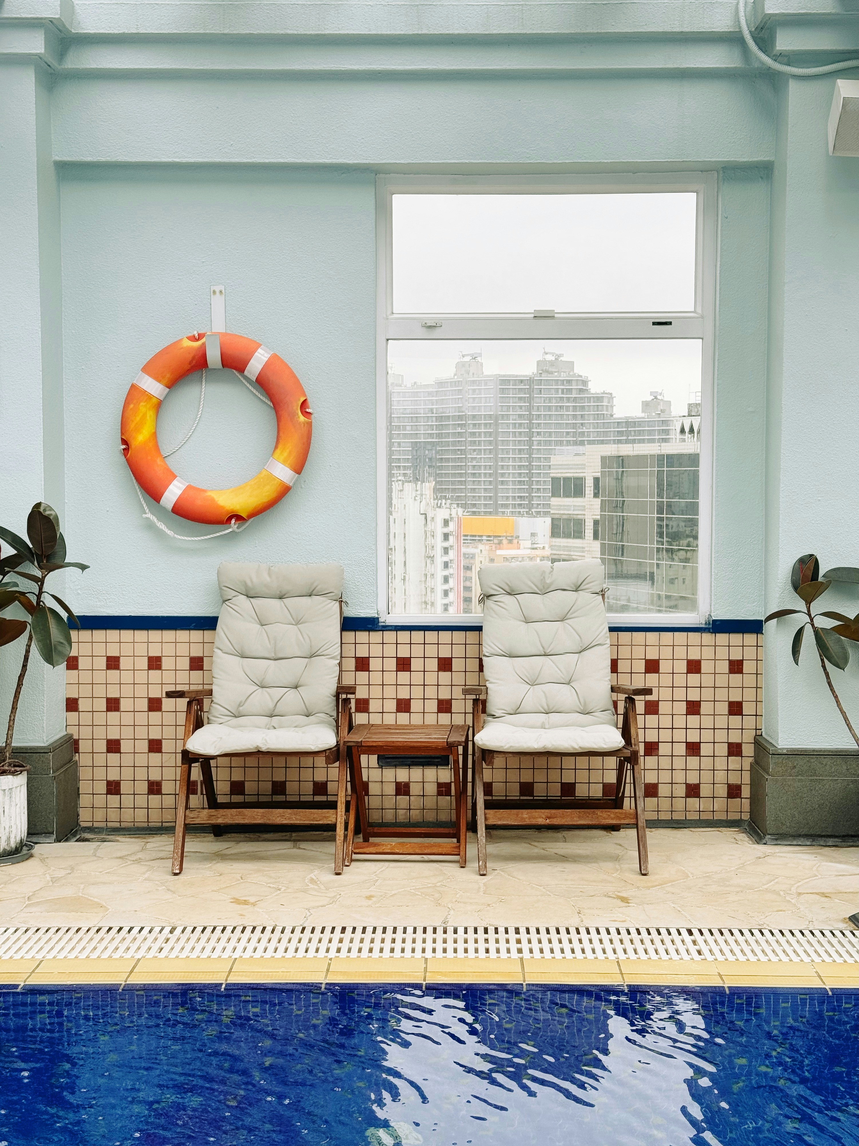 Una piscina con sillas y un salvavidas