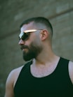 A man in a black tank top and sunglasses