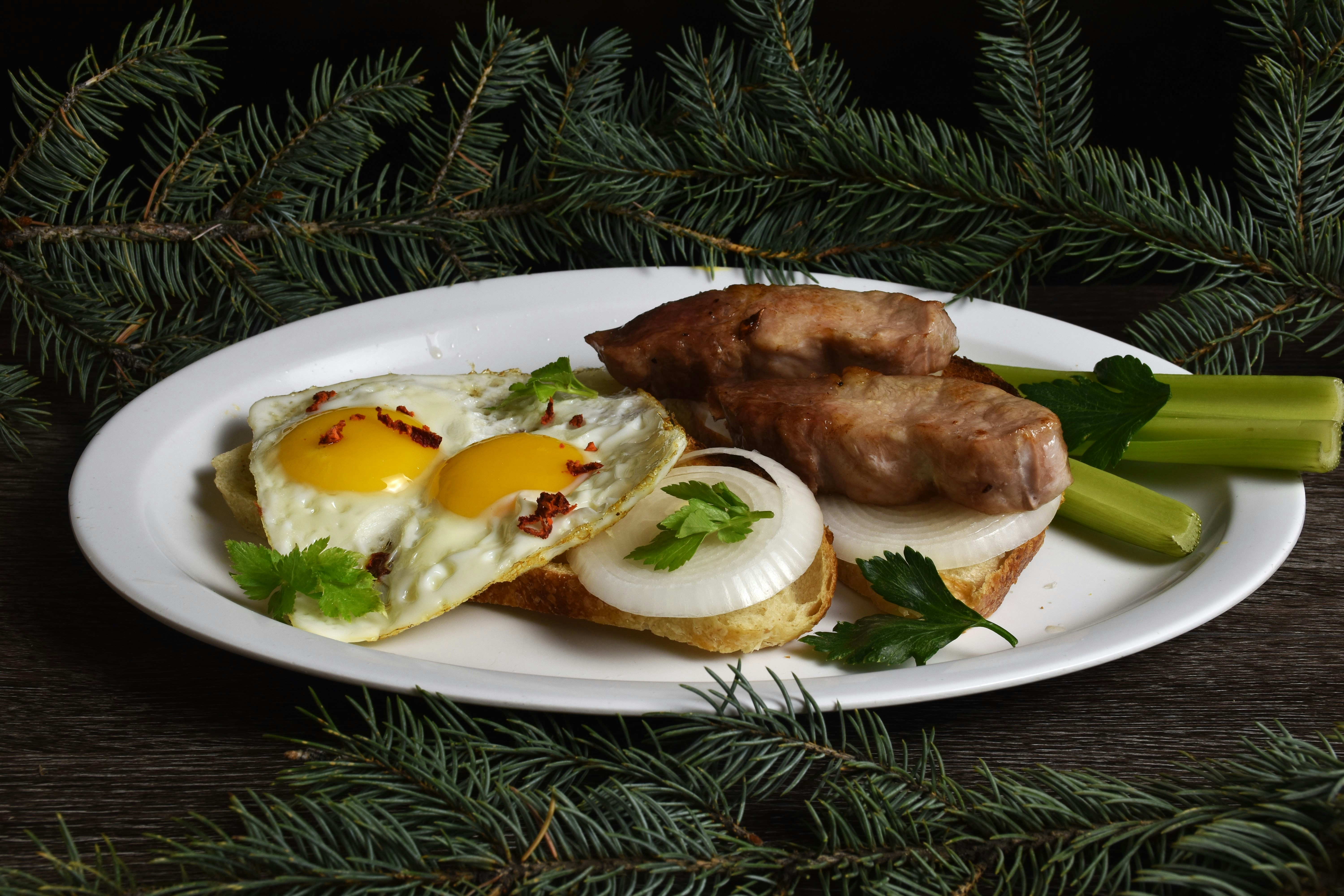 Fried eggs and sausages on a white plate