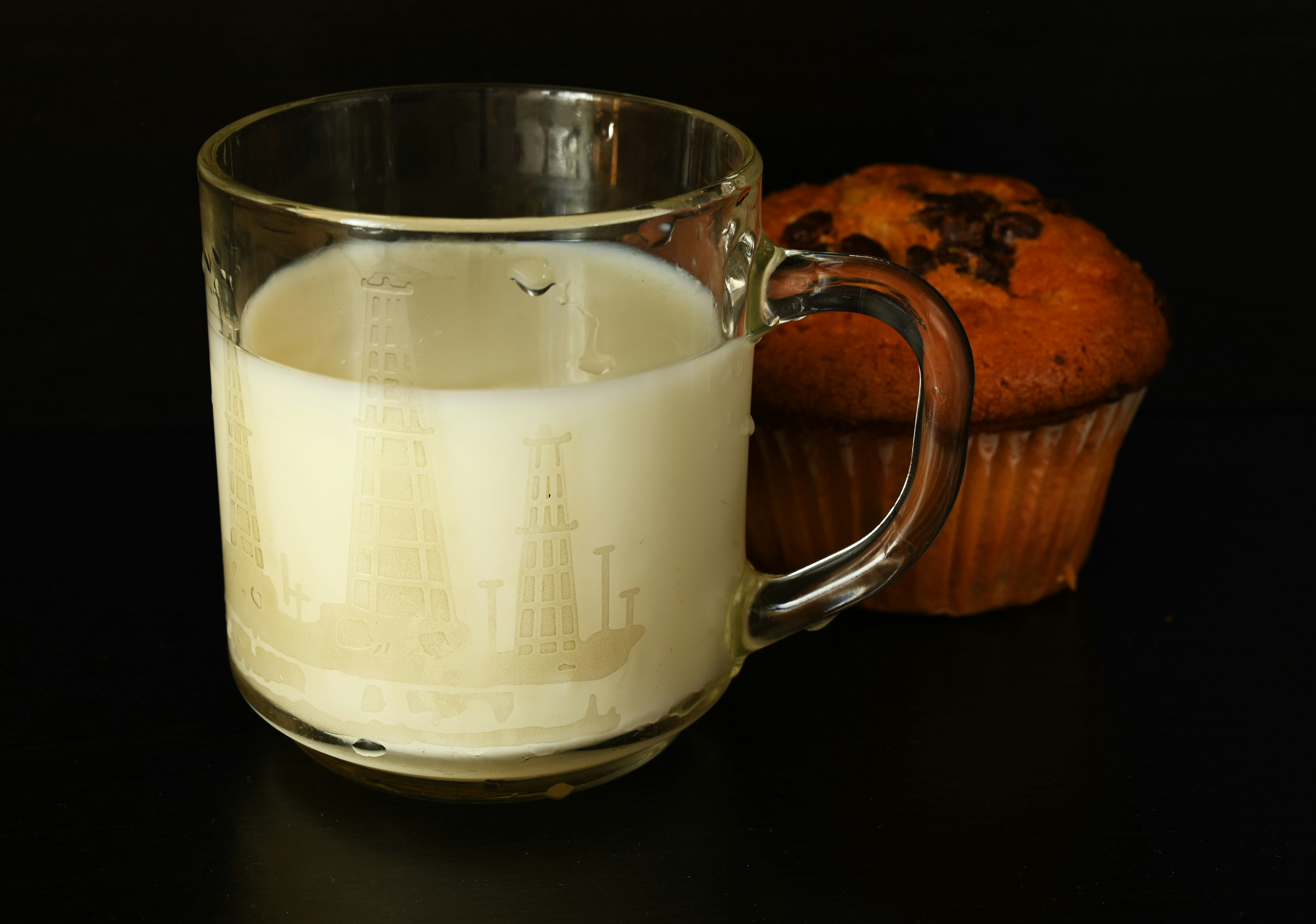 A glass of milk next to a muffin