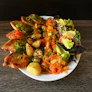 A white plate topped with meat and vegetables