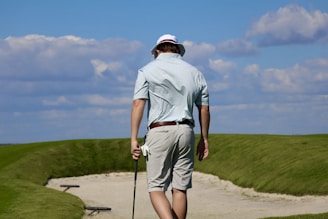 A man walking on a path with a golf club