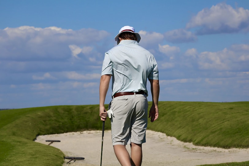 A man walking on a path with a golf club