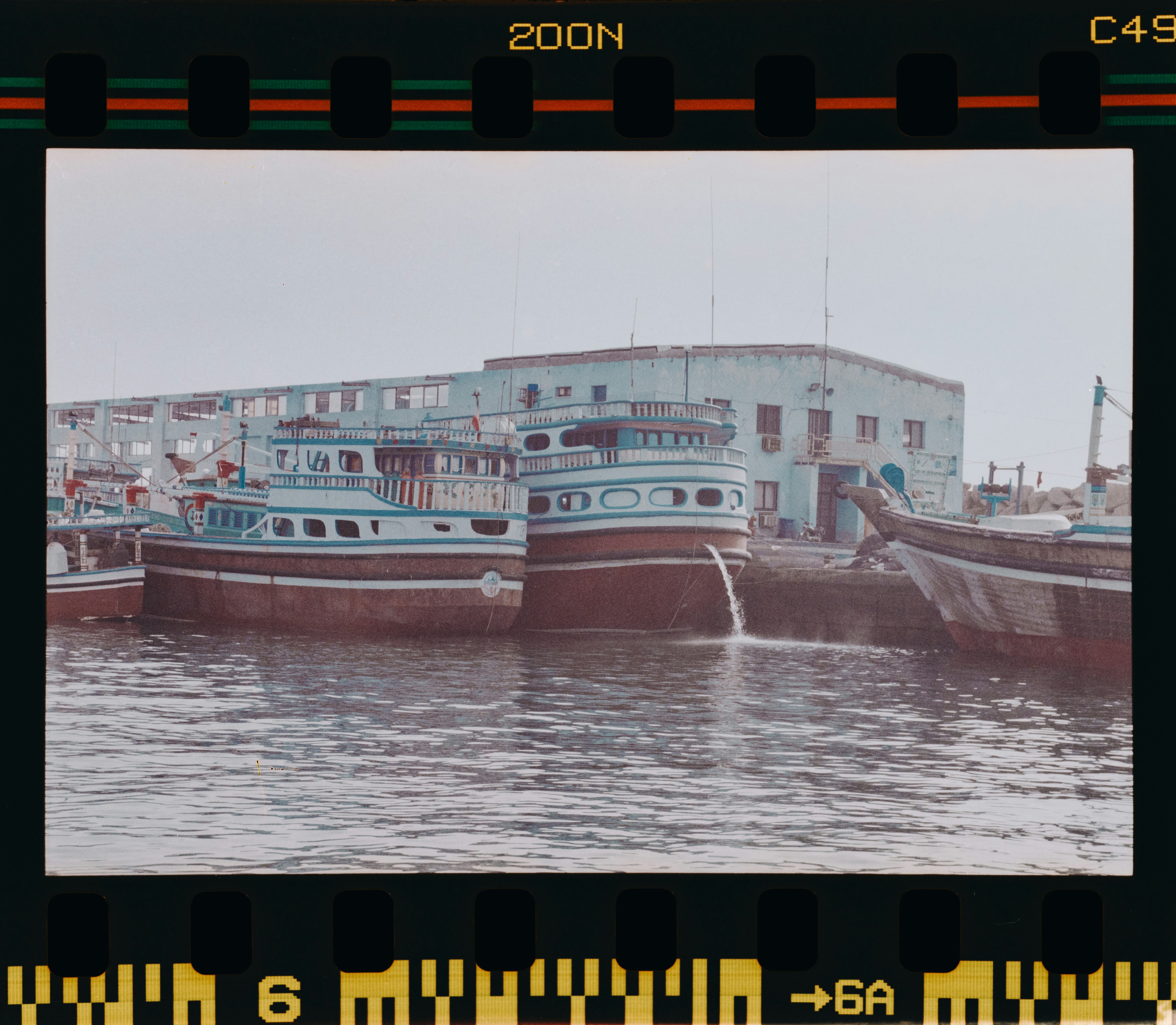 Abdul Majid Hakim Elahi speaking passionately at a podium with an Indian and Iranian flag in the background, a diverse audience listening attentively.