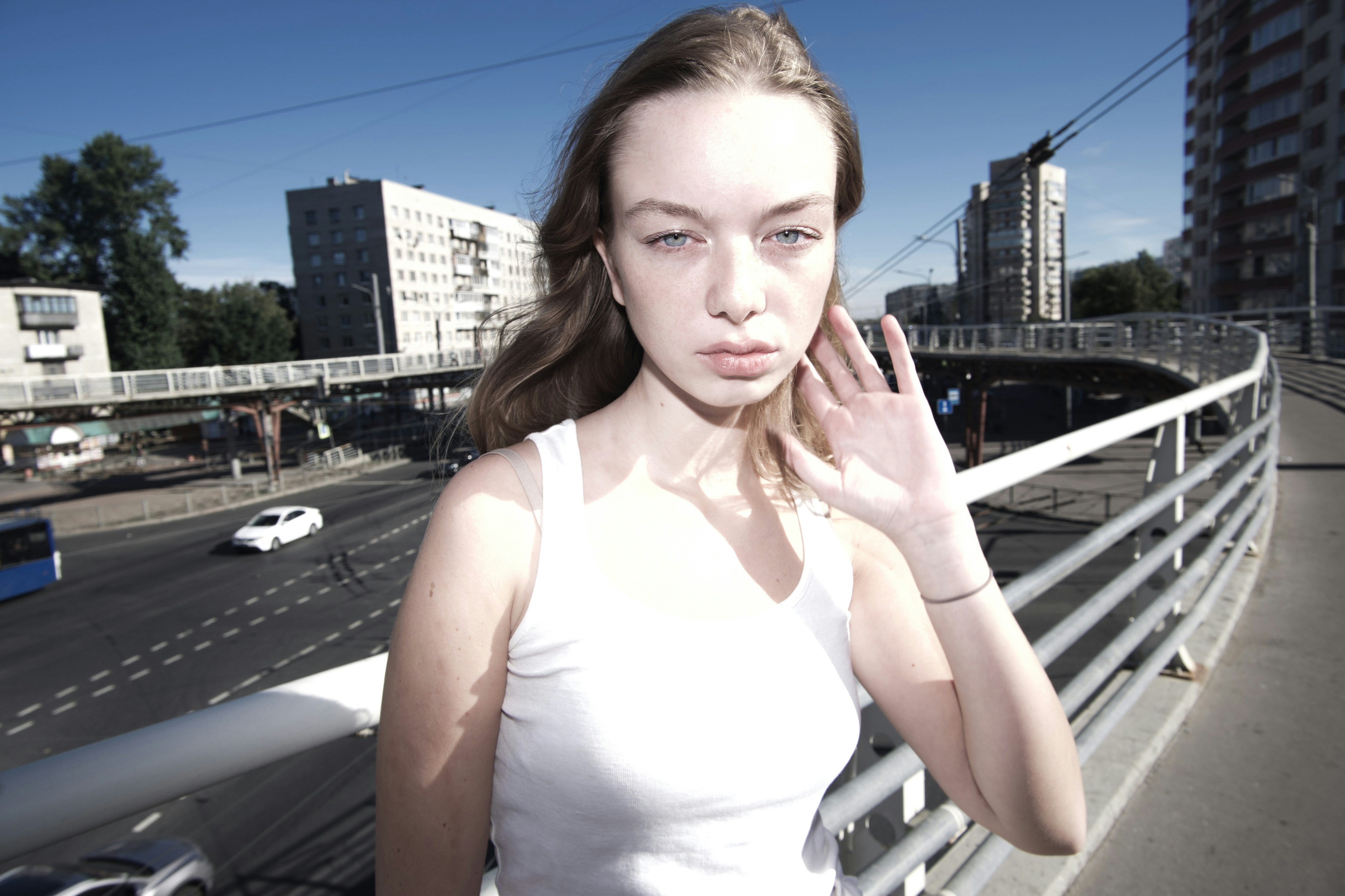A woman standing on a bridge talking on a cell phone