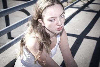 A woman sitting on a bench with her hand on her chin