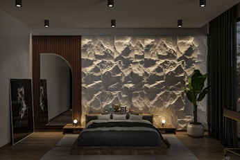 A bedroom with a stone wall and a large bed