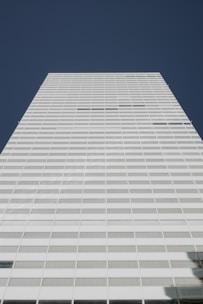 A tall white building with a sky background