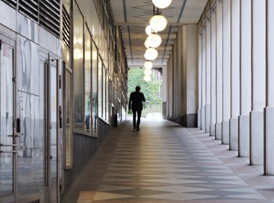 A man is walking down a long hallway