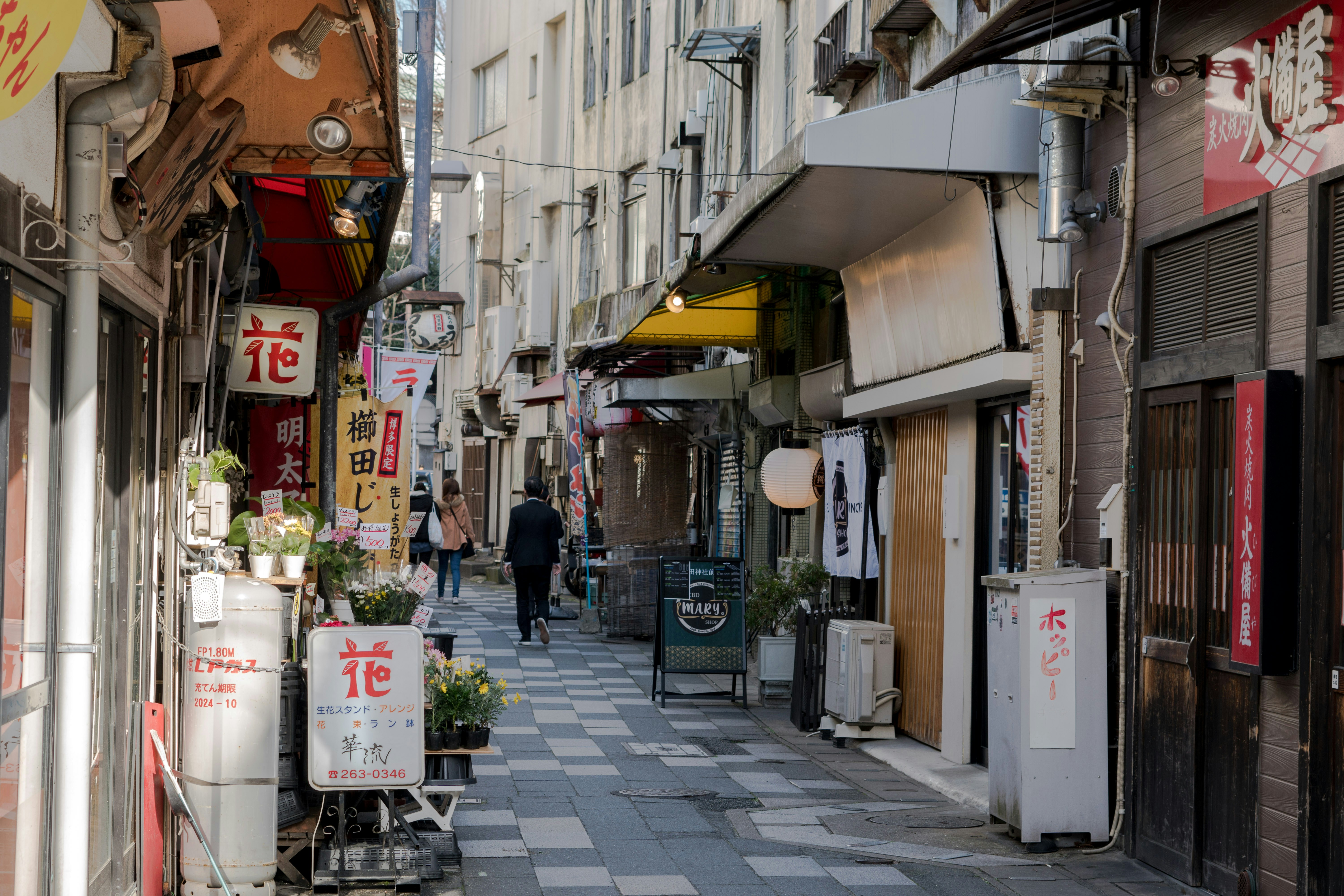 Uma rua estreita da cidade repleta de prédios e lojas