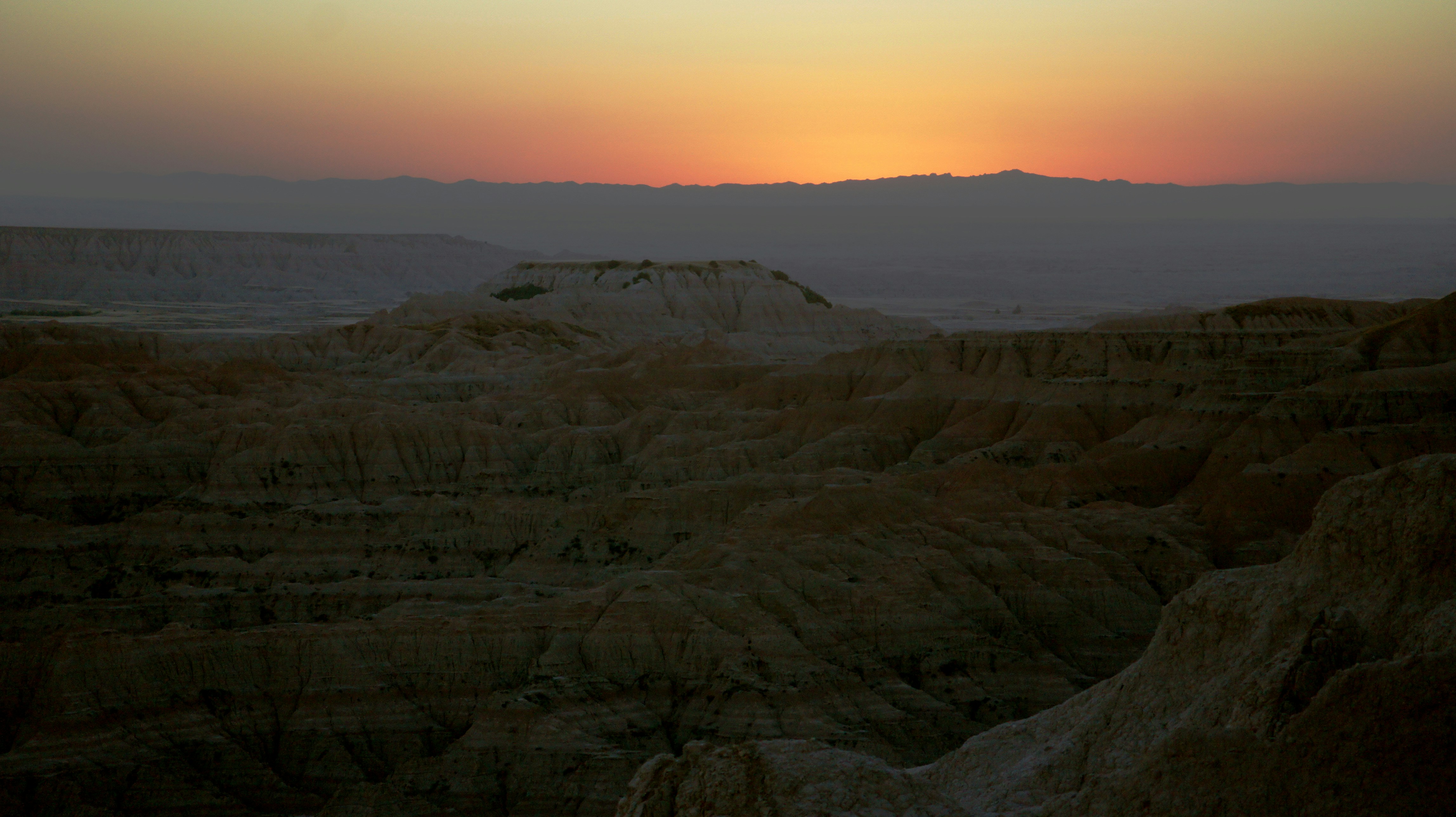 The sun is setting over the mountains in the desert