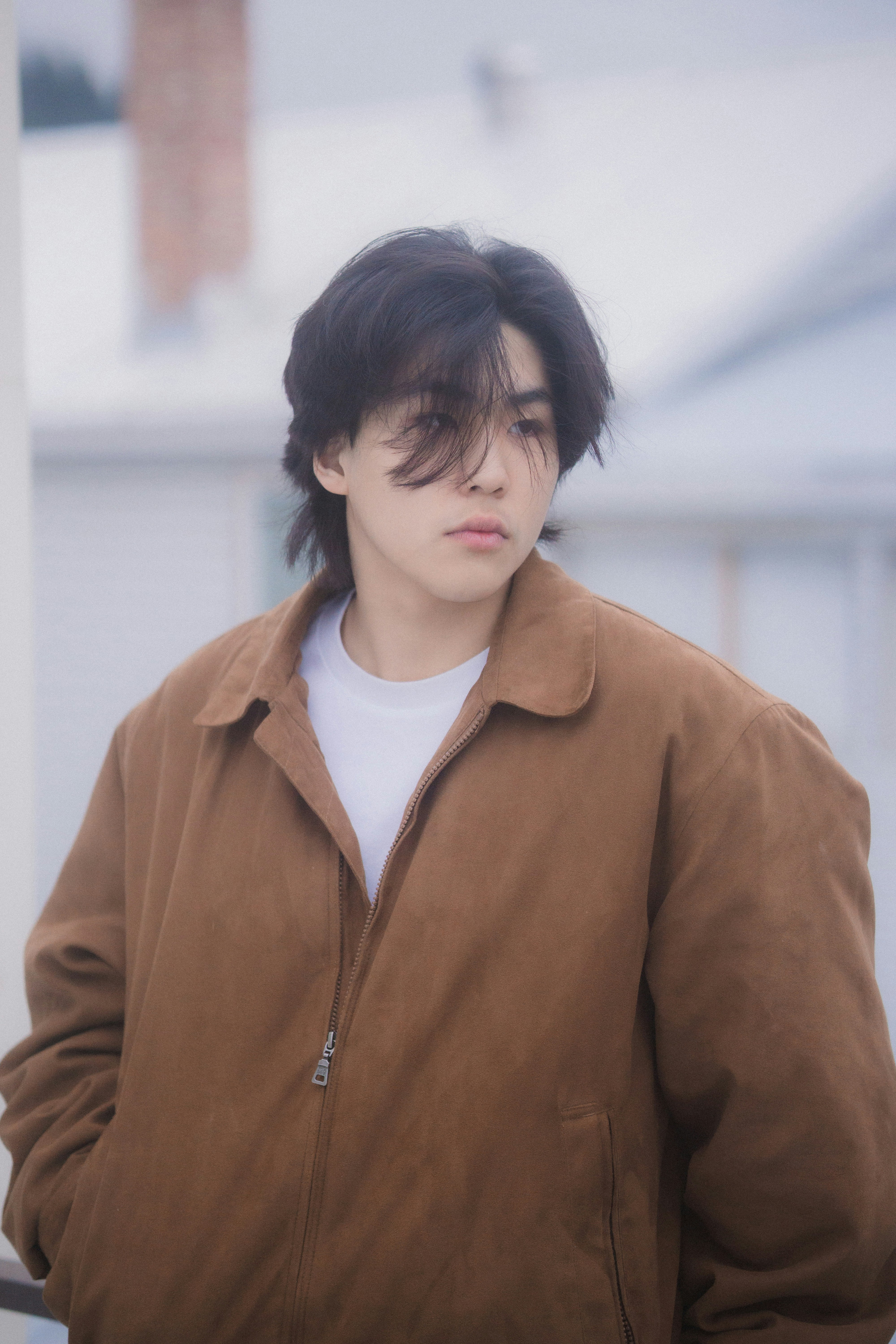 A young man standing next to a building