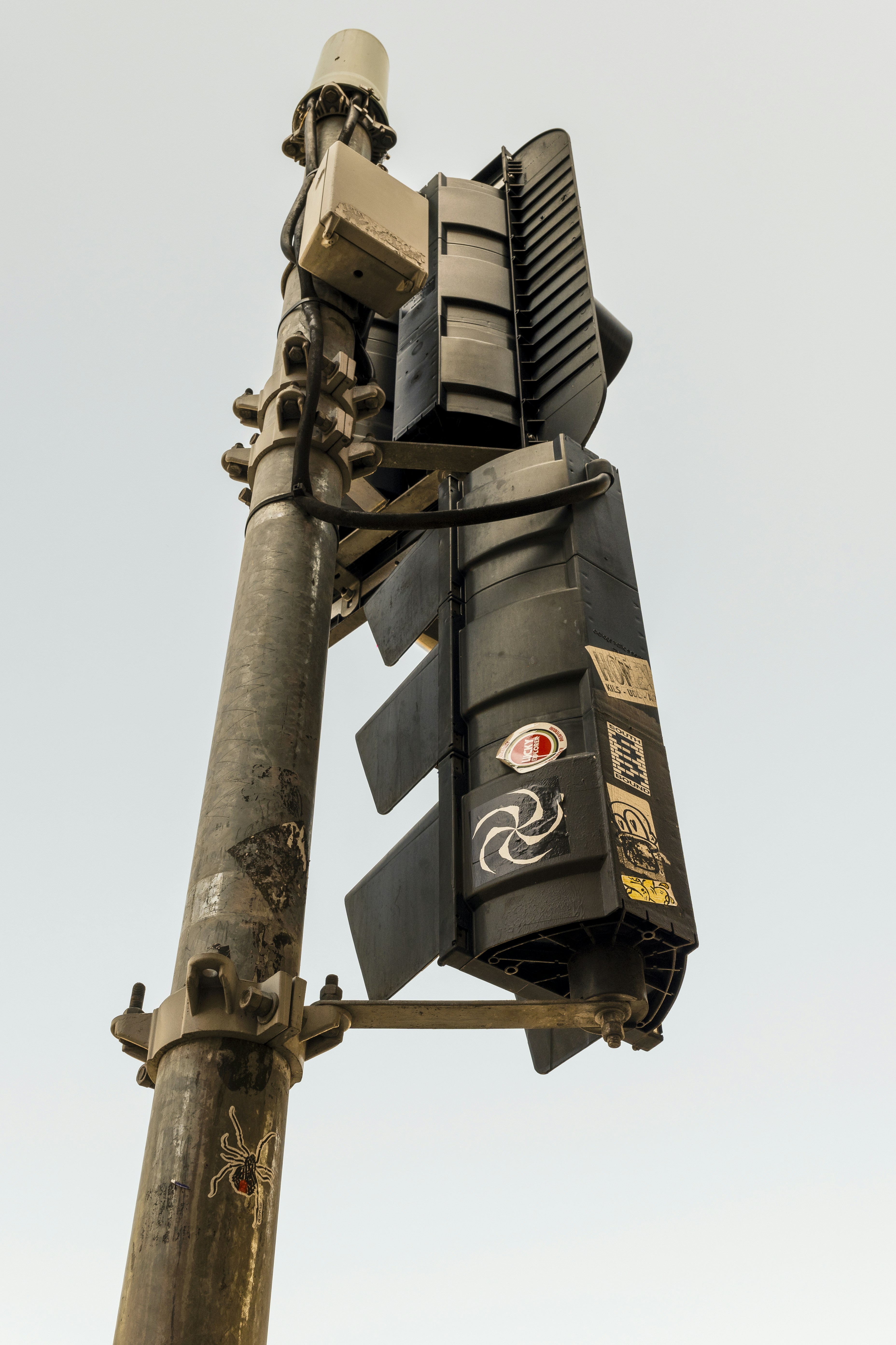 A traffic light on a pole with a sky background
