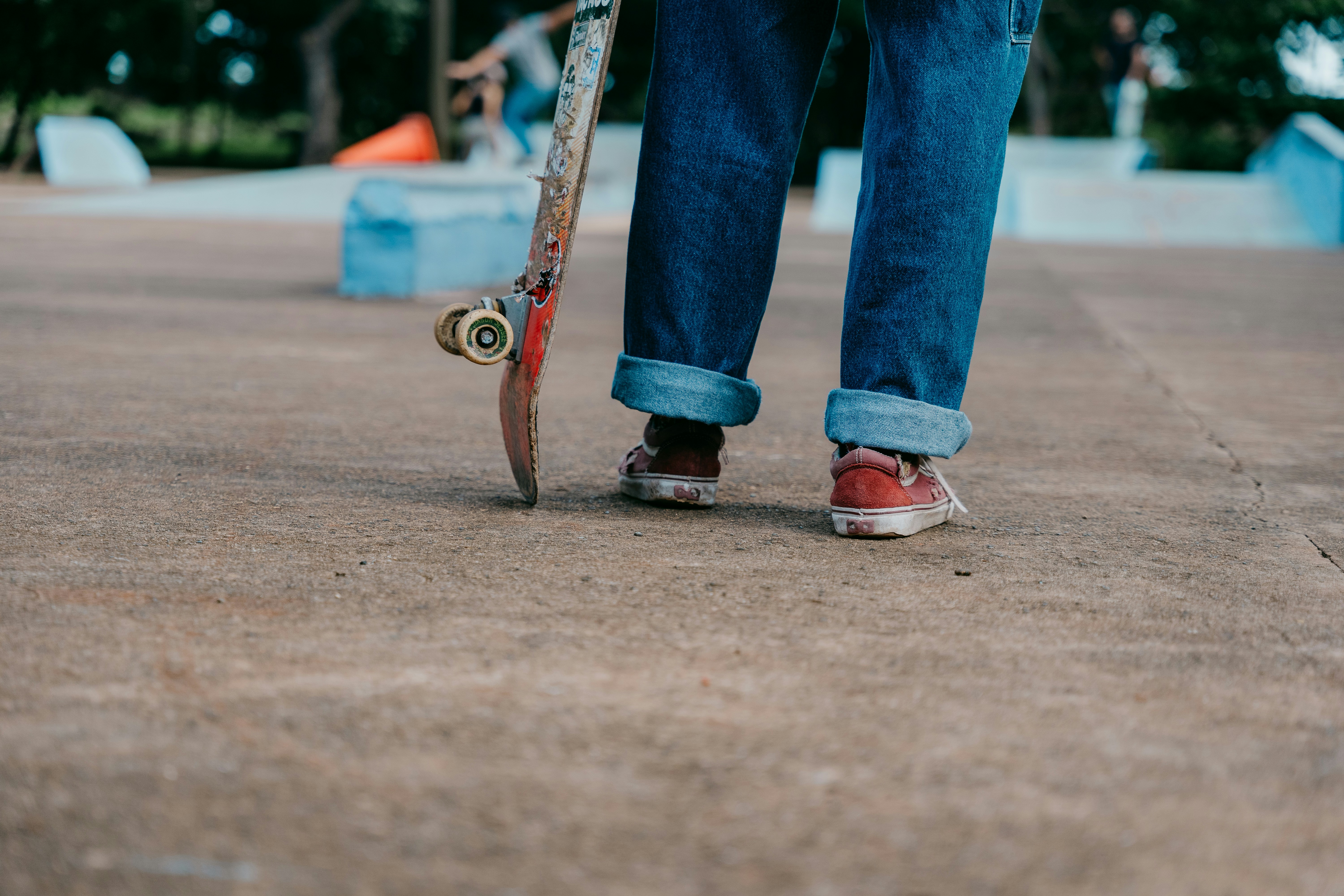 Una persona con uno skateboard su una superficie di cemento