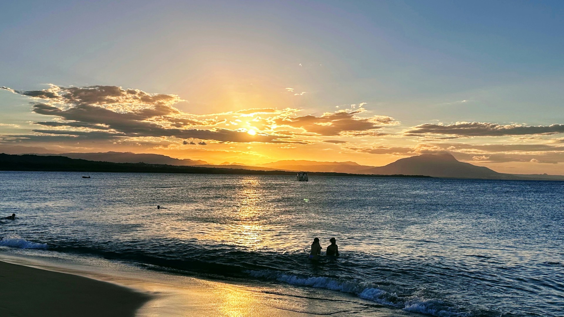 The sun is setting over the ocean on the beach