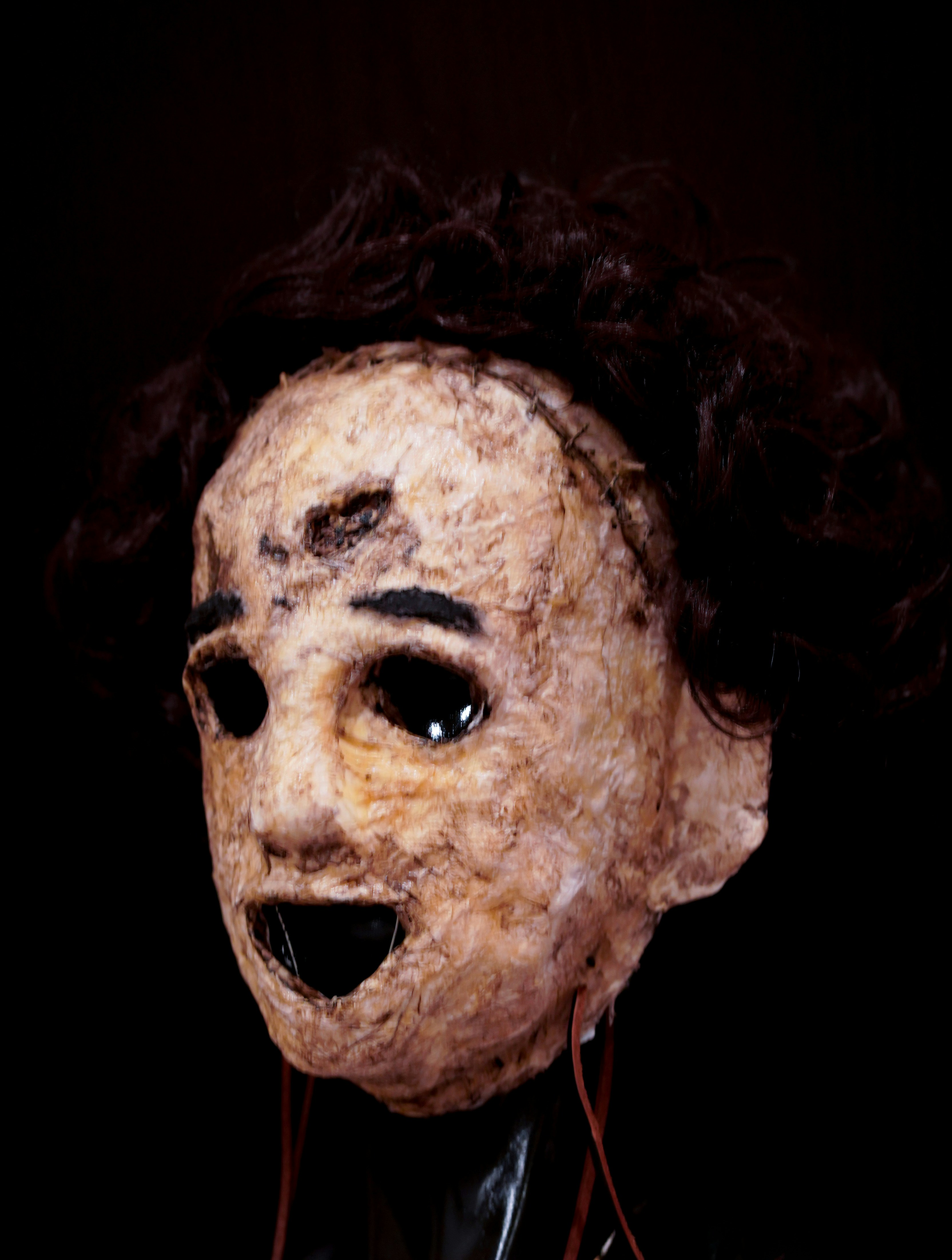 A person wearing a creepy mask with long hair