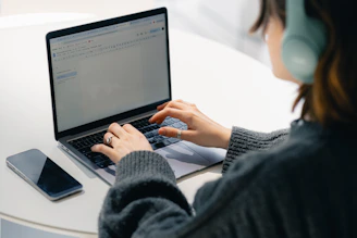 A woman sitting at a table using a laptop computer