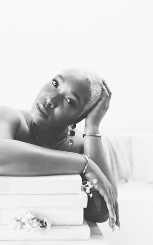 A woman laying on top of a stack of books