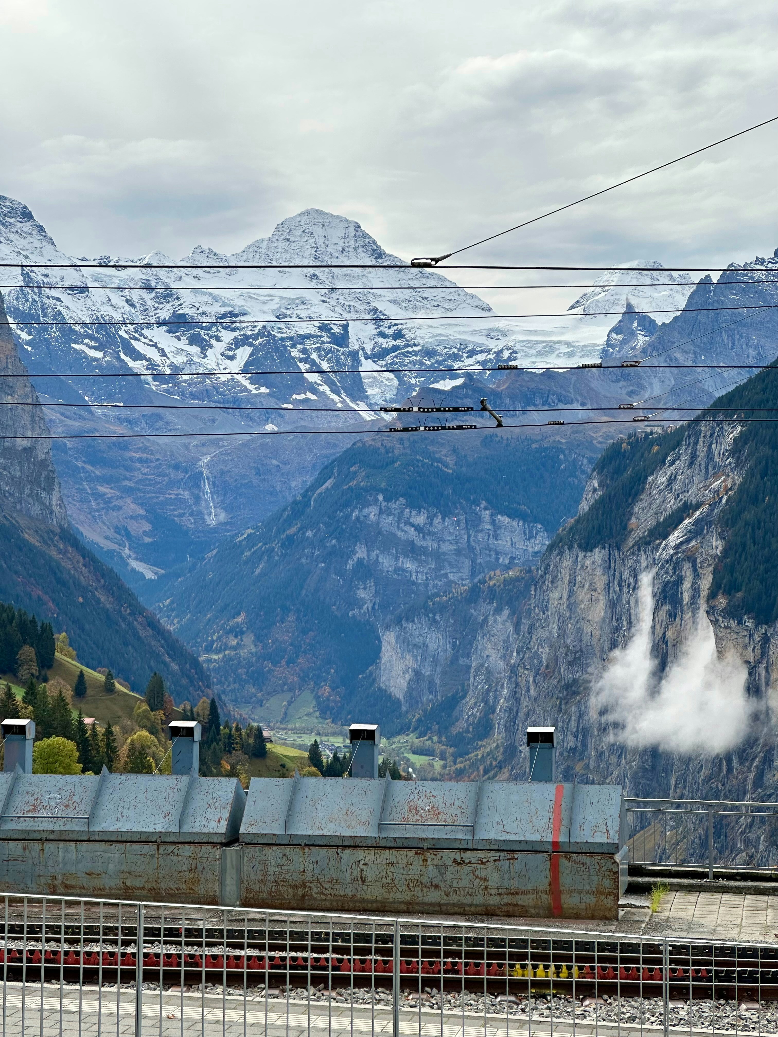 A train traveling through a mountain valley with mountains in the background
