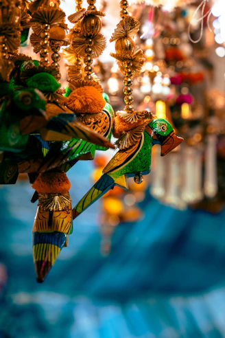 A colorful bird decoration hanging from a chandelier