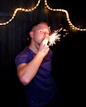 A man holding a sparkler in front of his face