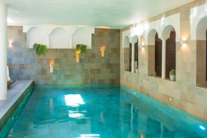 A large indoor swimming pool with blue water
