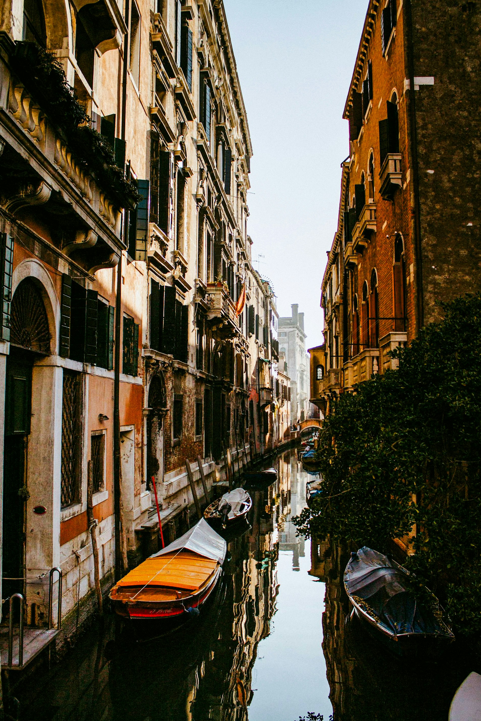 A narrow canal with several boats in it
