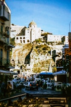 A group of people walking down a street next to tall buildings