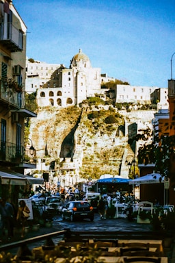 A group of people walking down a street next to tall buildings