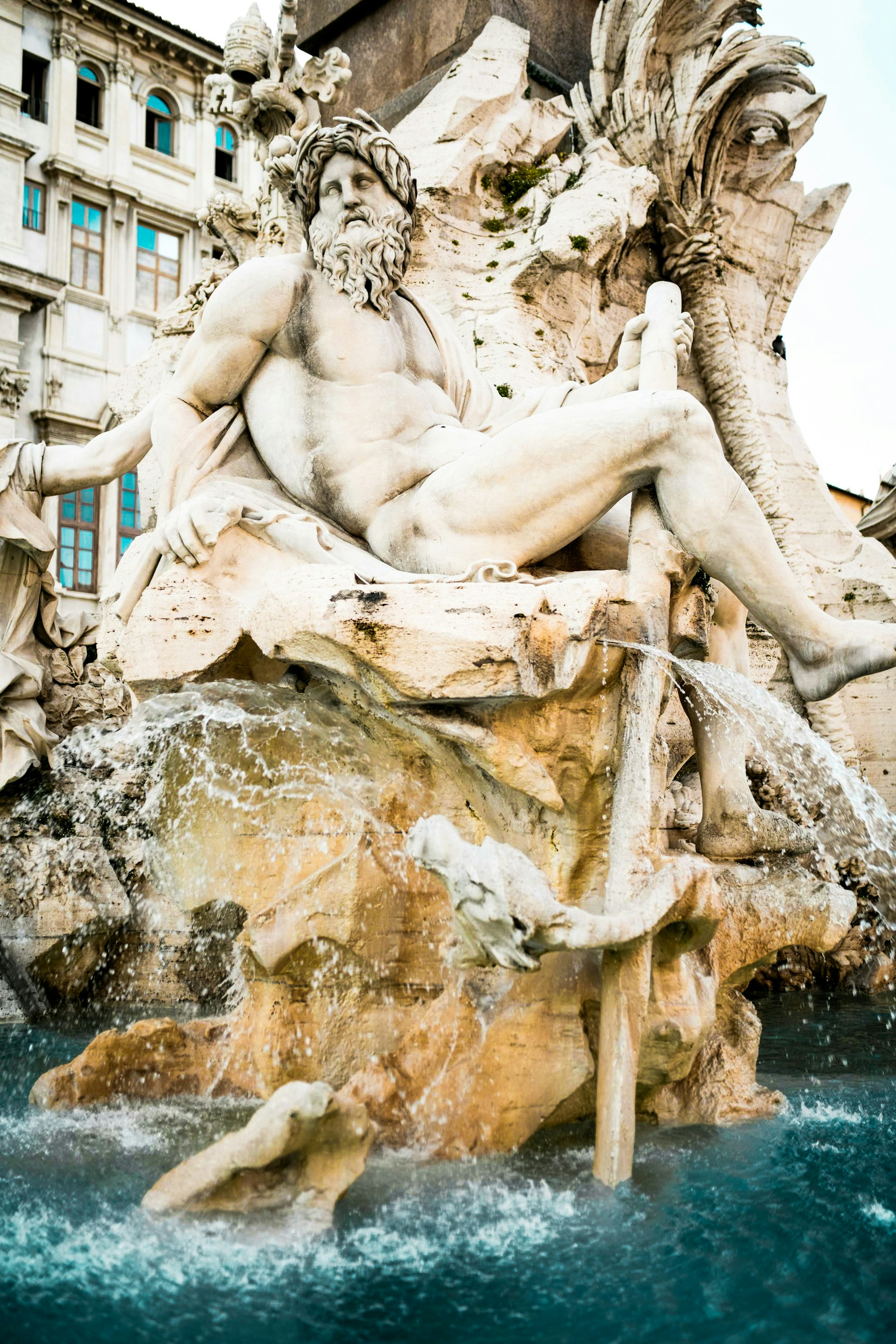 A statue of a man sitting on top of a fountain